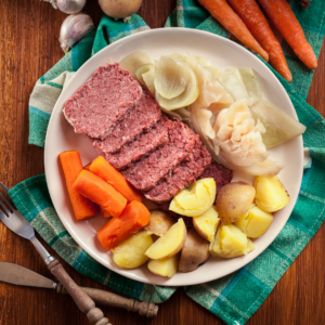 A plate filled with corned beef, potatoes, carrots and cabbage