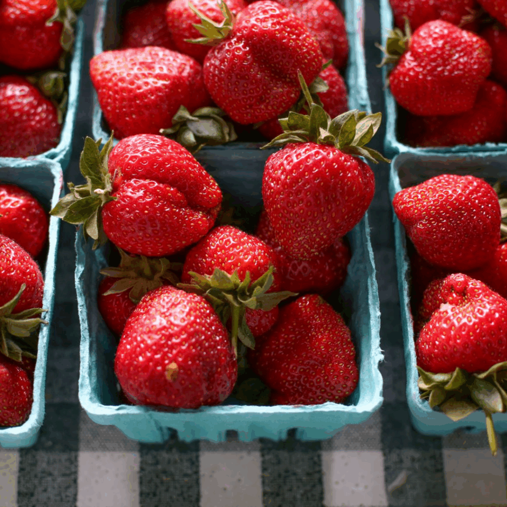 strawberries in pints on a table for sale