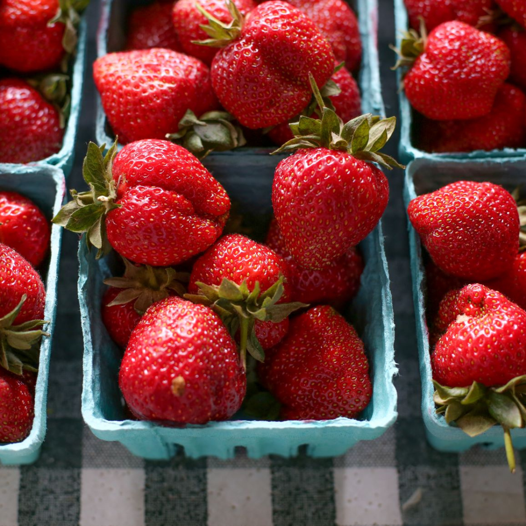 strawberries in pints on a table for sale