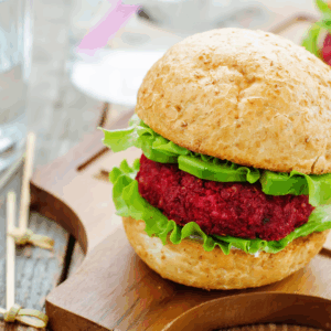 A beet quinoa patty on a bun with lettuce and avocado