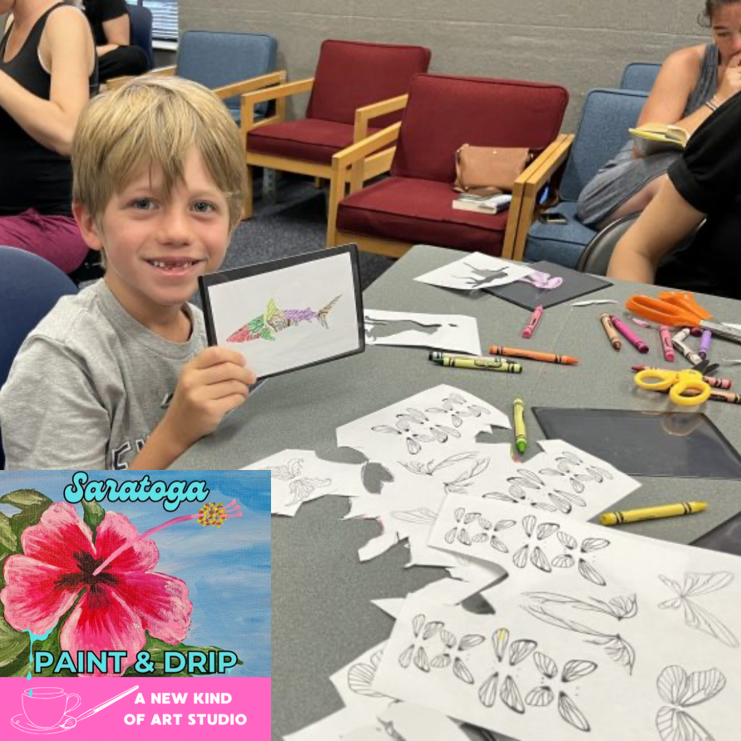 A child holding up art for Saratoga Paint and Drip Event